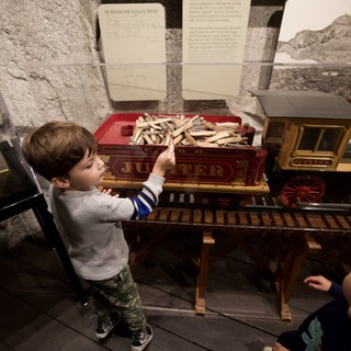 Young Child Explores Interactive Train Exhibit at Museum