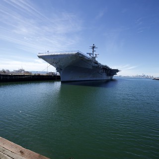Historic Aircraft Carrier Docked in Tranquil Harbor