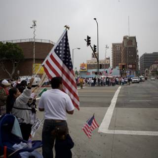 Great American Boycott Protestors Hold Two Flags on City Corner