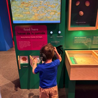 Young Boy Explores Interactive Museum Exhibit with Headphones