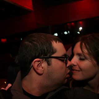 Intimate Moment: Couple Kissing in Dimly Lit Bar