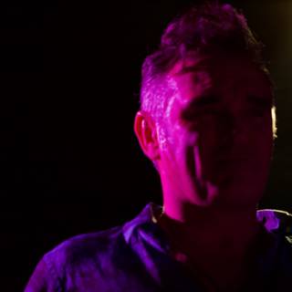 Morrissey stands in the Purple Spotlight