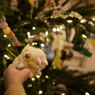 Child's Hand Holding White Snowman Christmas Ornament
