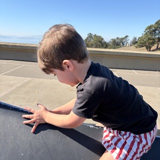 Young Boy Playing on Rooftop Parking Structure