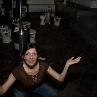 Woman Gestures Expressively in Dark Nightclub Venue