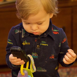 Toddler Mesmerized by Toy Vehicle at Christmas