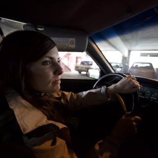 Woman Driving Through Urban Parking Structure at Night
