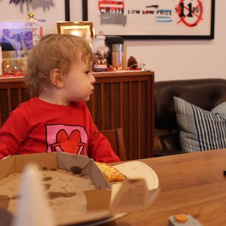 Young Child Eating Pizza at Christmas Dinner Table
