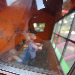 Hand Holding Toy Through Display Case Reflection