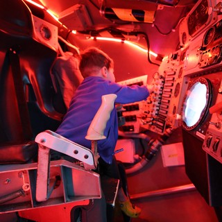 Young Visitor Operating Submarine Simulator at Science Center