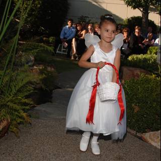 Little Girl in a Formal White Gown at a Garden Wedding