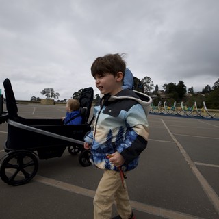 Young Boy Pulling Wagon on Cloudy Day at Parking Lot