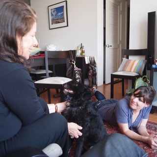 Two Women Bonding with Black Dog Indoors