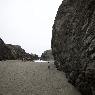 Small Child Explores Dramatic Coastal Rock Canyon