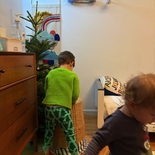 Brothers Decorating Christmas Tree Together in Bedroom