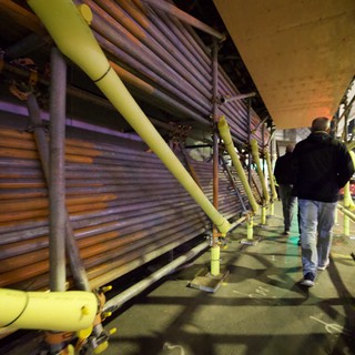 Evening Walk Under Urban Infrastructure with Yellow Safety Rails