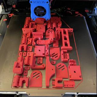Red plastic car model being printed by 3D printer