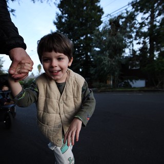 Joyful Child Holding Parent's Hand at Dusk