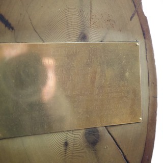 Weathered Brass Memorial Plaque on Wooden Post
