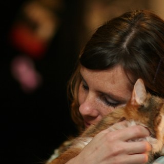 Woman Tenderly Embraces Orange Tabby Cat