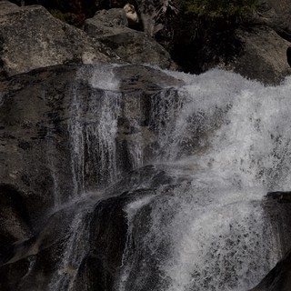 Cascading Waters Through Dark Rocky Terrain
