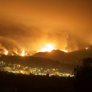 Flames Consume Hills Above Cityscape