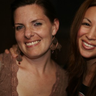 Two Women Smiling Together at a Nighttime Event