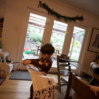Child Building Cardboard Playhouse on Christmas Day