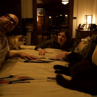 Couple and Cats Relaxing on Patterned Blanket at Home