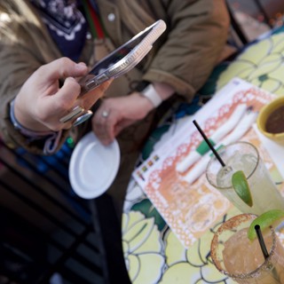 Scrolling Through Margaritas at Outdoor Cafe