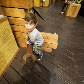 Young Boy Exploring Interactive Wood Construction Museum Exhibit