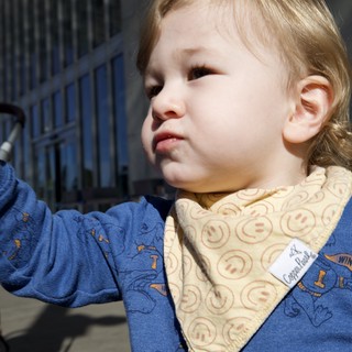 Young Child in Blue Patterned Outfit with Bib