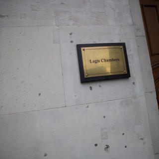 Legis Chambers Brass Plaque on Weathered White Wall