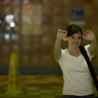 Playful Woman Making Bunny Ears in Warehouse