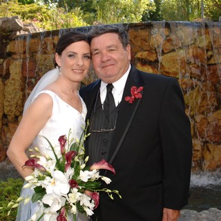 Bride and Groom Pose Before Waterfall Backdrop