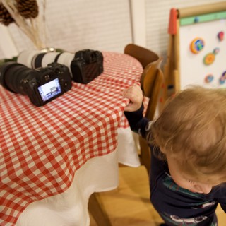 Curious Toddler Examining Professional Camera Equipment