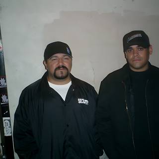 Two Men in Black Jackets Sporting Caps