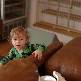 Toddler in Green Dinosaur Pajamas Playing at Home