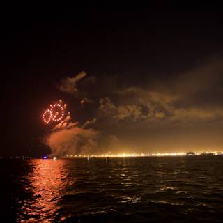 Bursting Fireworks over the Glittering Ocean