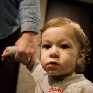Toddler Holding Parent's Hand in Warm Indoor Setting