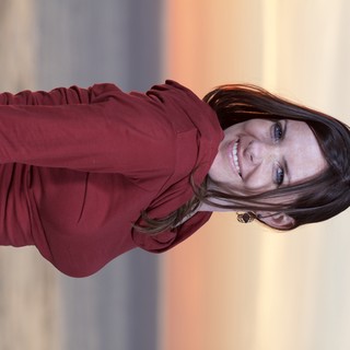 Smiling Woman at Coastal Sunset in Crimson Top