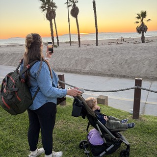 Mother Capturing Sunset Moment with Child at Beach