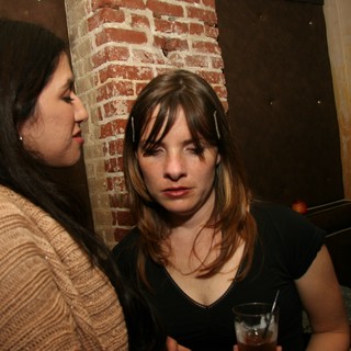 Two Women Conversing at a Dimly Lit Bar