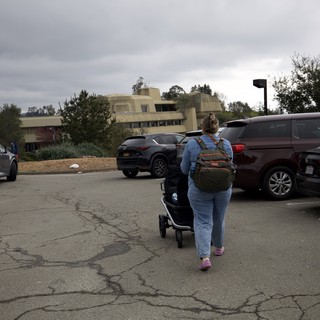 Mother and Child Navigate Parking Lot on Overcast Day