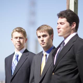 Three Men in Suits Under a Blue Sky