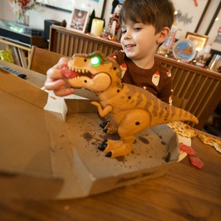 Child Playing with Interactive T-Rex Toy on Christmas