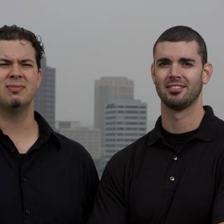 Two Happy Men in Black Shirts by Skyscraper
