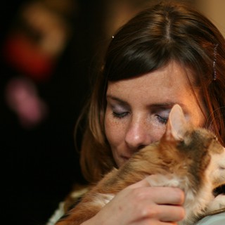 Tender Moment: Woman Nuzzles Beloved Ginger Kitten