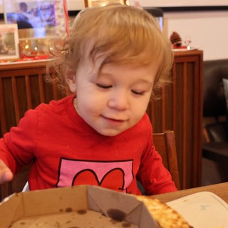 Toddler Enjoying Pizza at Christmas Dinner