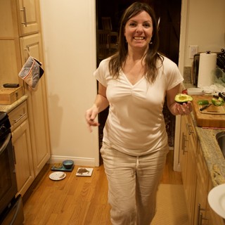 Woman Holding Fresh Avocado in Cozy Kitchen
